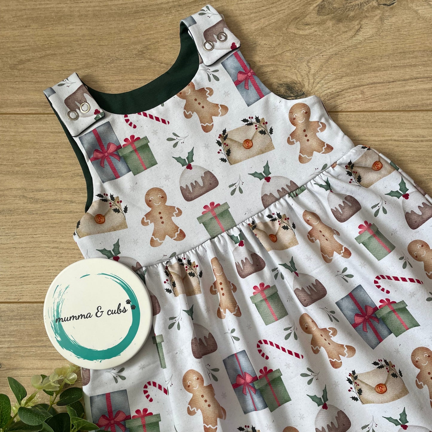 Children's dress with Christmas gingerbread pattern on a wooden surface