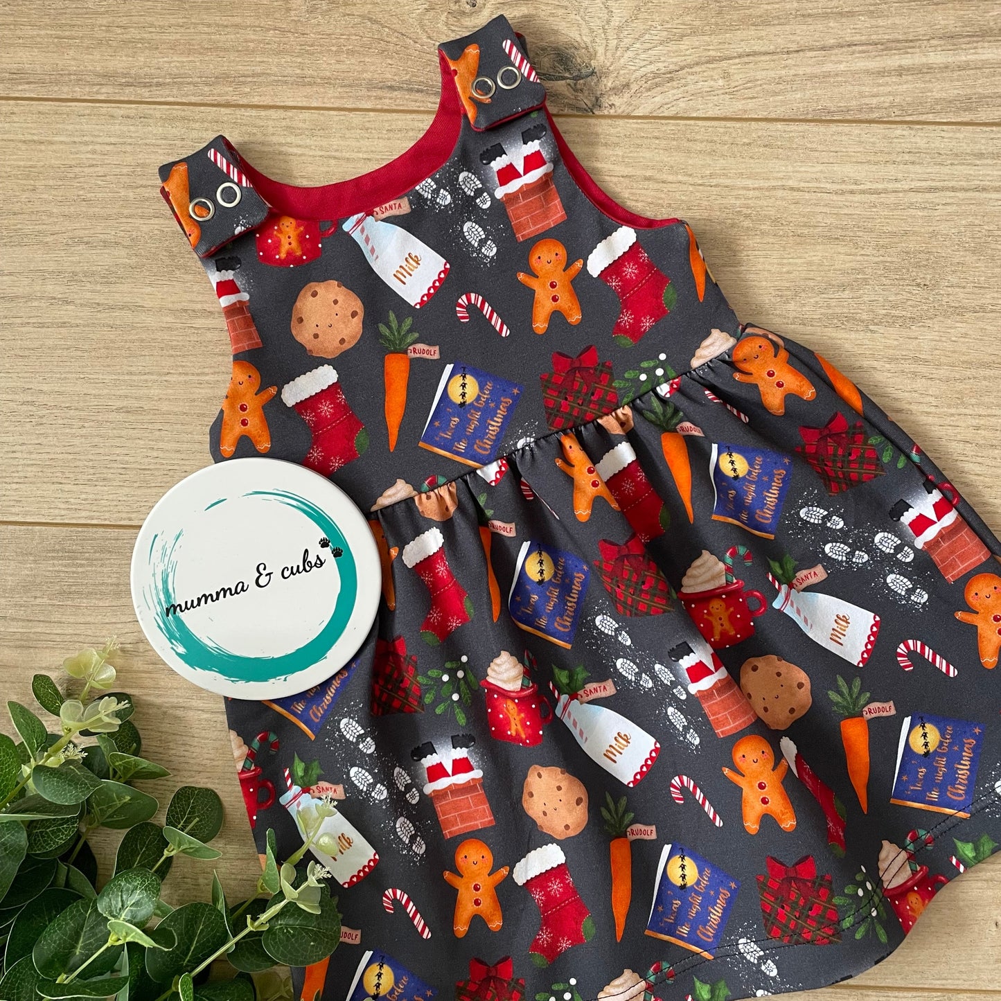 Christmas-themed dress with festive designs on a wooden surface.