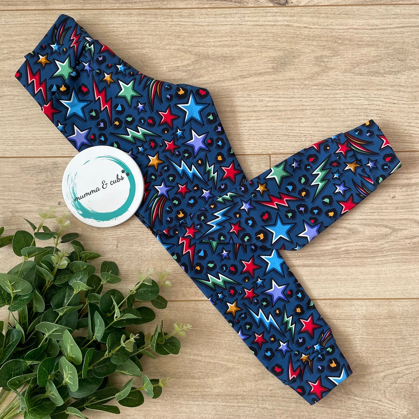 Colourful star-patterned childrens leggings in navy blue with bright red, green yellow stars and lightening bolts