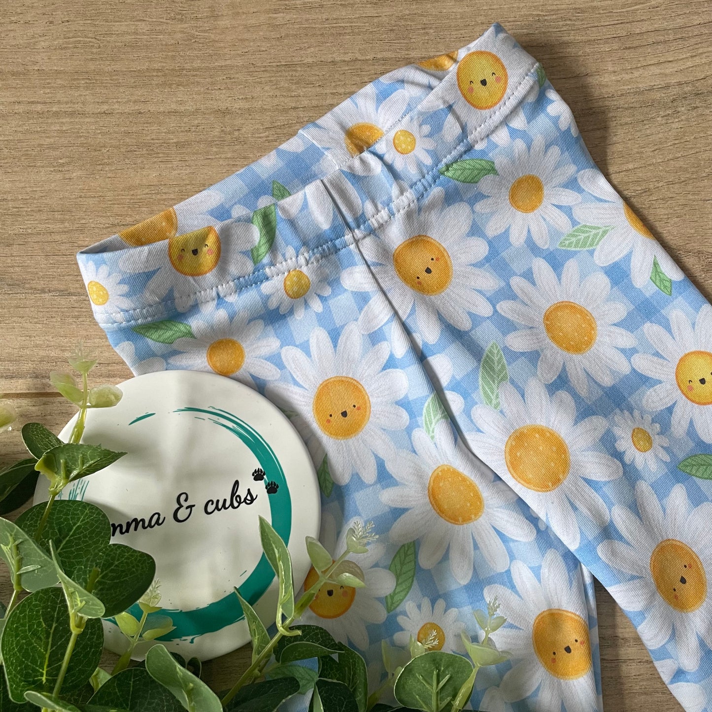 Baby leggings with daisy pattern on a blue gingham background