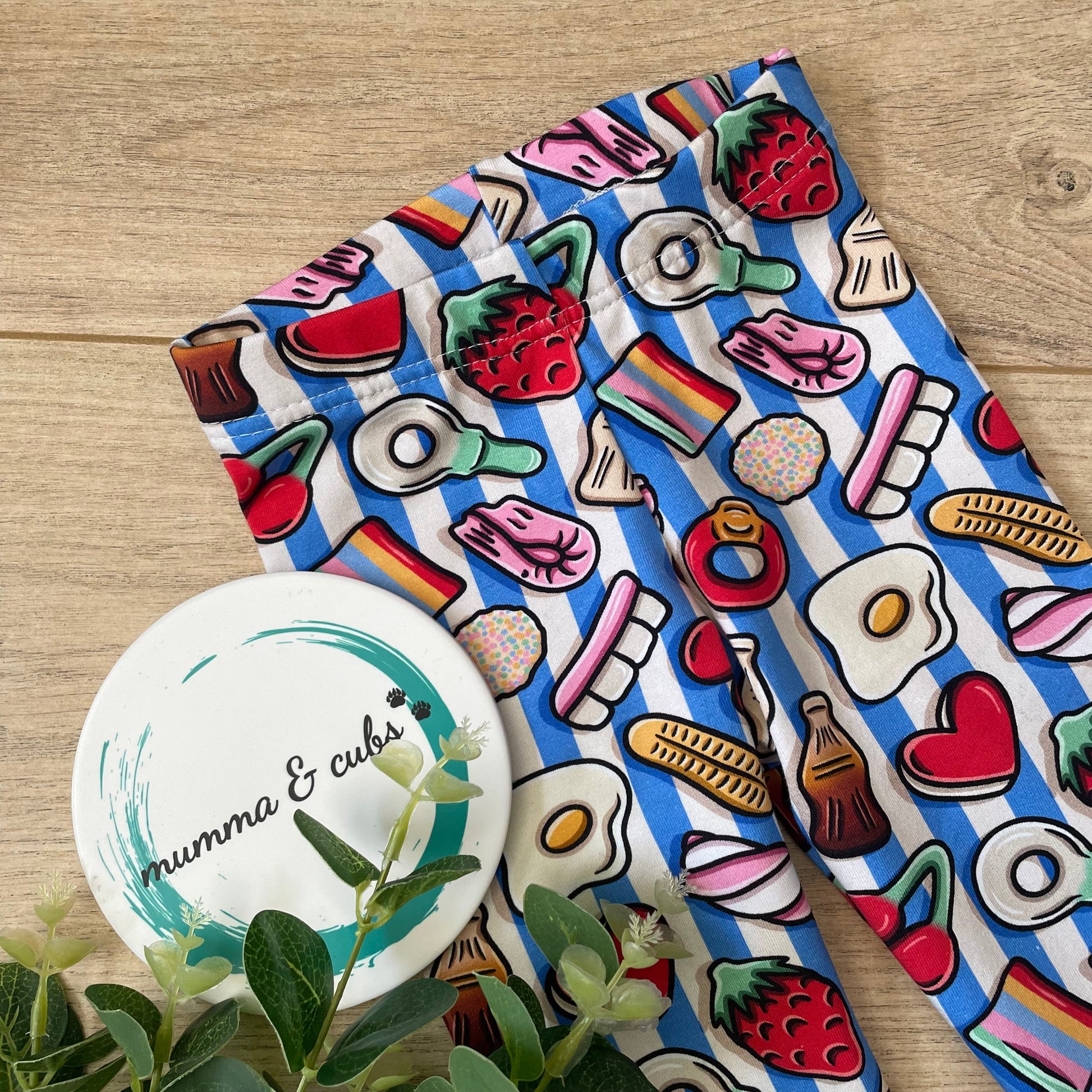 Colourful fabric with food-themed designs showing an elasticated waist on childrens leggings