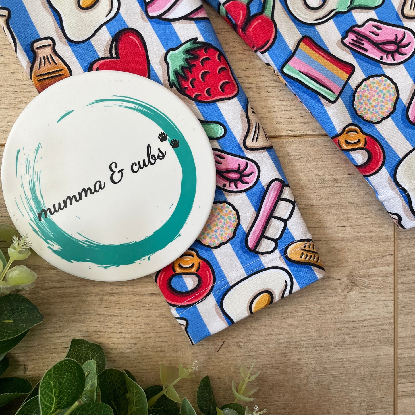Close up of hemmed leggings that are in a sweets design including bananas, cherries and eggs