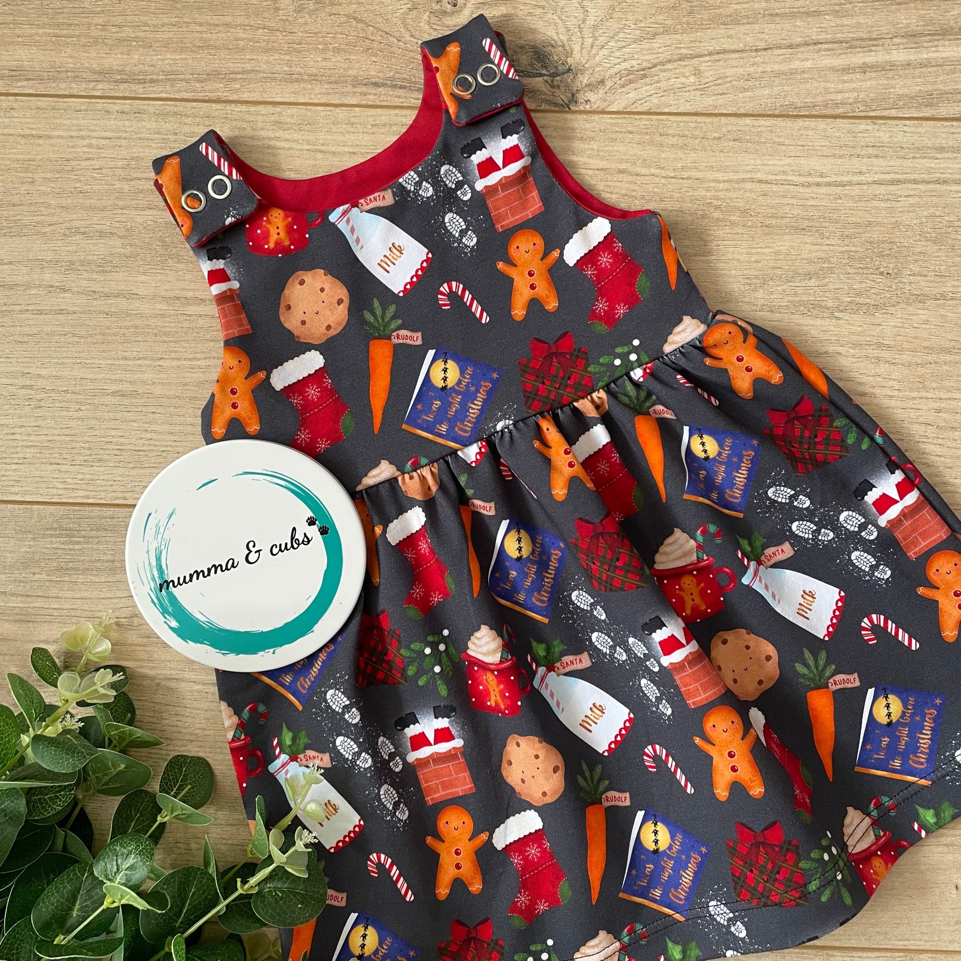 Christmas-themed dress with festive designs on a wooden surface.