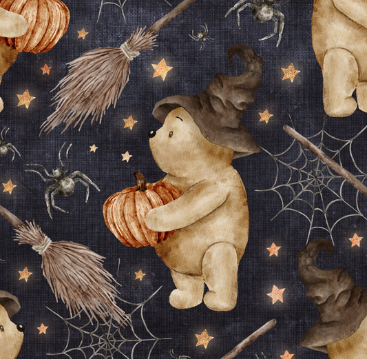 Bear holding pumpkin and wearing a witches hat on a navy background with spiders, webs and broomsticks