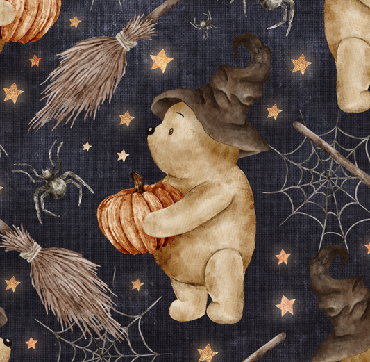 Bear holding pumpkin and wearing a witches hat on a navy background with spiders, webs and broomsticks